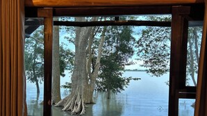 Ein Zimmer mit Blick auf einen See, einer Bank und einer Klimaanlage.