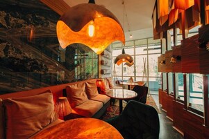 Un interior moderno con sofá, mesas redondas e iluminación colgante.
