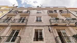 A multi-story building with patterned facade, balconies with wrought iron railings, and multiple windows. - Cosy Loft Heart Of The City! (Lisbon)