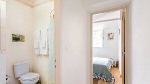 A bathroom with a toilet, a shower, and a towel rack. - Trendy Loft Heart Of The City! (Lisbon)