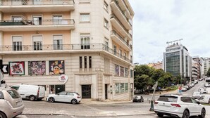 A multi-story hotel with balconies, a parking lot, and a street view. - Top Location Beautiful Apartment! (Lisbon)