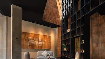 A modern lounge area with a sofa, a coffee table, and a bookshelf.
