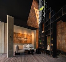 A modern lounge area with a sofa, a coffee table, and a bookshelf.