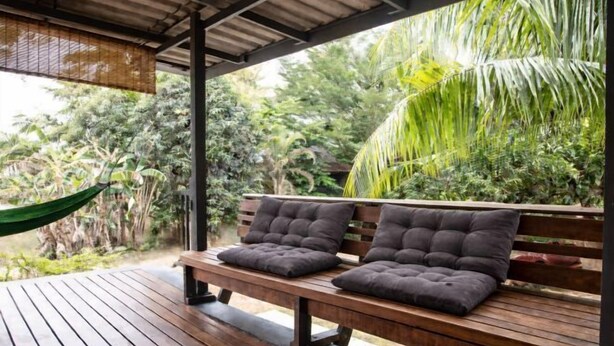 A wooden bench with cushions, a hammock, and a view of tropical foliage. - Island’s Gift – Private Design House for 2 Near Sunset Beach (Koh Phangan)