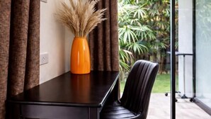 A room with a dark wooden table, a black leather chair, and a vase with dried plants. - Island’s Gift – Private Design House for 2 Near Sunset Beach (Koh Phangan)