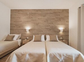A hotel room with two beds, wooden headboard, bedside lamps, and a neutral color scheme. - Hotel Orion Vodice (Vodice)