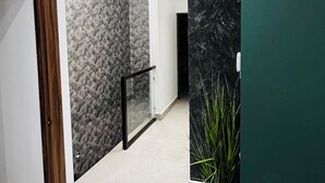 A hallway with a marble wall, a potted plant, and a door frame. - Casa Niagara discovers this luxury place for you (Juárez)