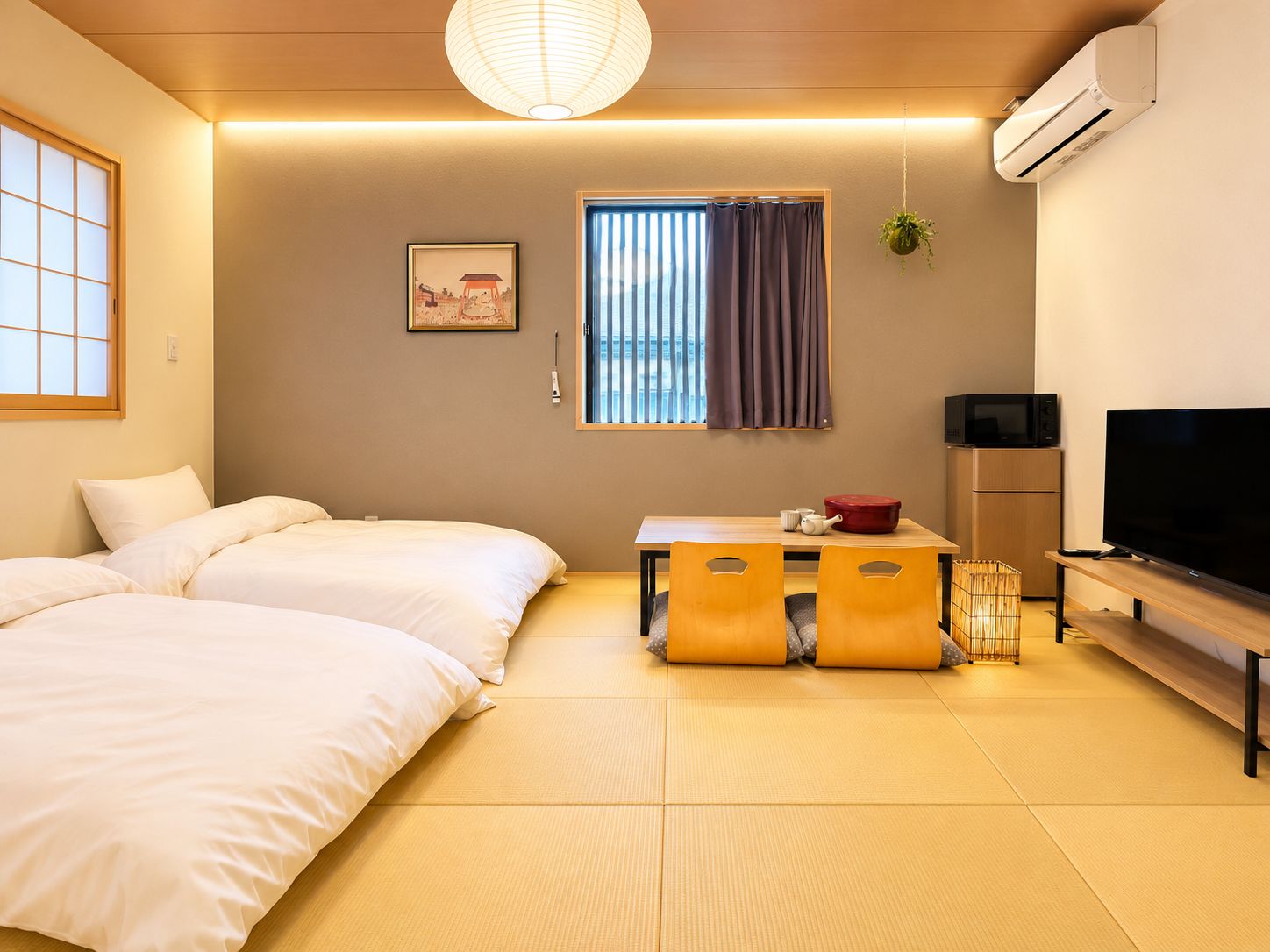A hotel room with two beds, a television, a small table with a red pot, and a window with curtains.