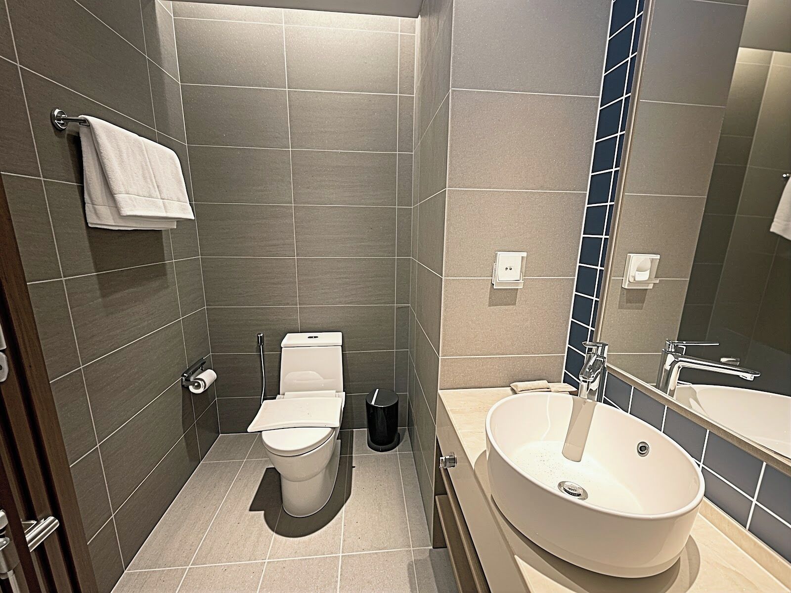 A modern bathroom with a toilet, bidet, and sink.