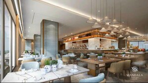 Un interior de restaurante moderno con mesas de mármol, lámparas colgantes y una zona de bar central.