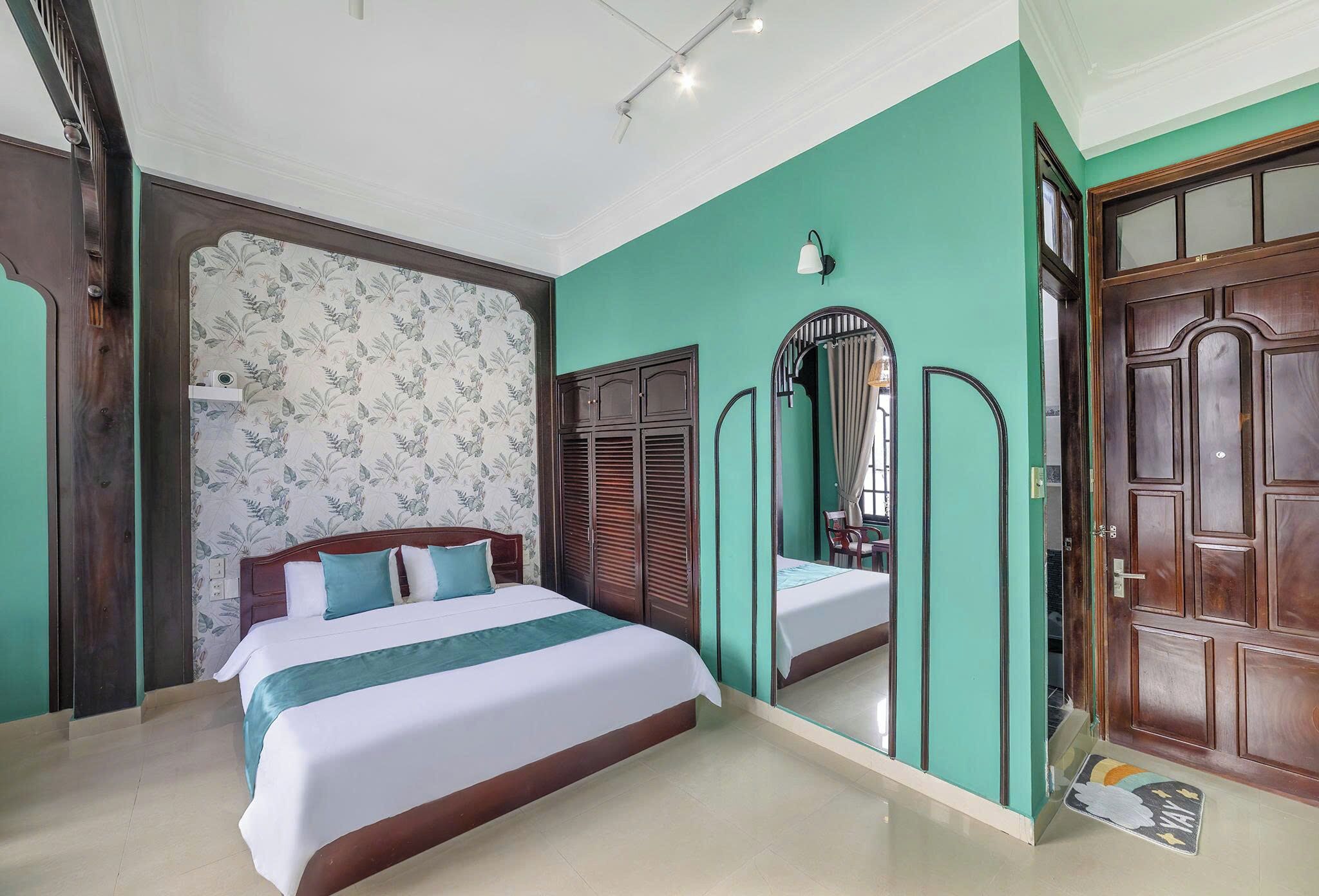 Una camera da letto con un letto grande, uno specchio e una porta in legno.
