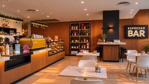 A modern bar area with a coffee machine, seating, and a sign reading 'ESPRESSO BAR'. - Skyline Suites | Stunning City Views, Gym & Pool (Southbank)