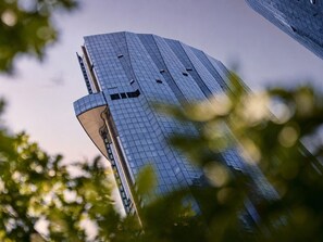 A tall, modern building with a glass facade and a unique angular design. - Skyline Suites | Stunning City Views, Gym & Pool (Southbank)