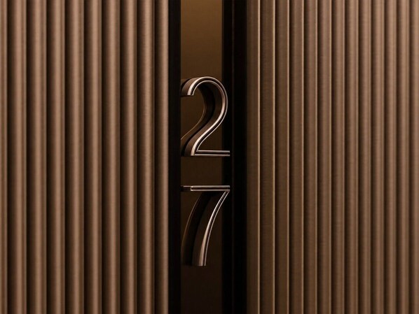 A close-up of a metallic number '27' on a textured surface. - Skyline Suites | Stylish Corner Suite, City Views (Southbank)