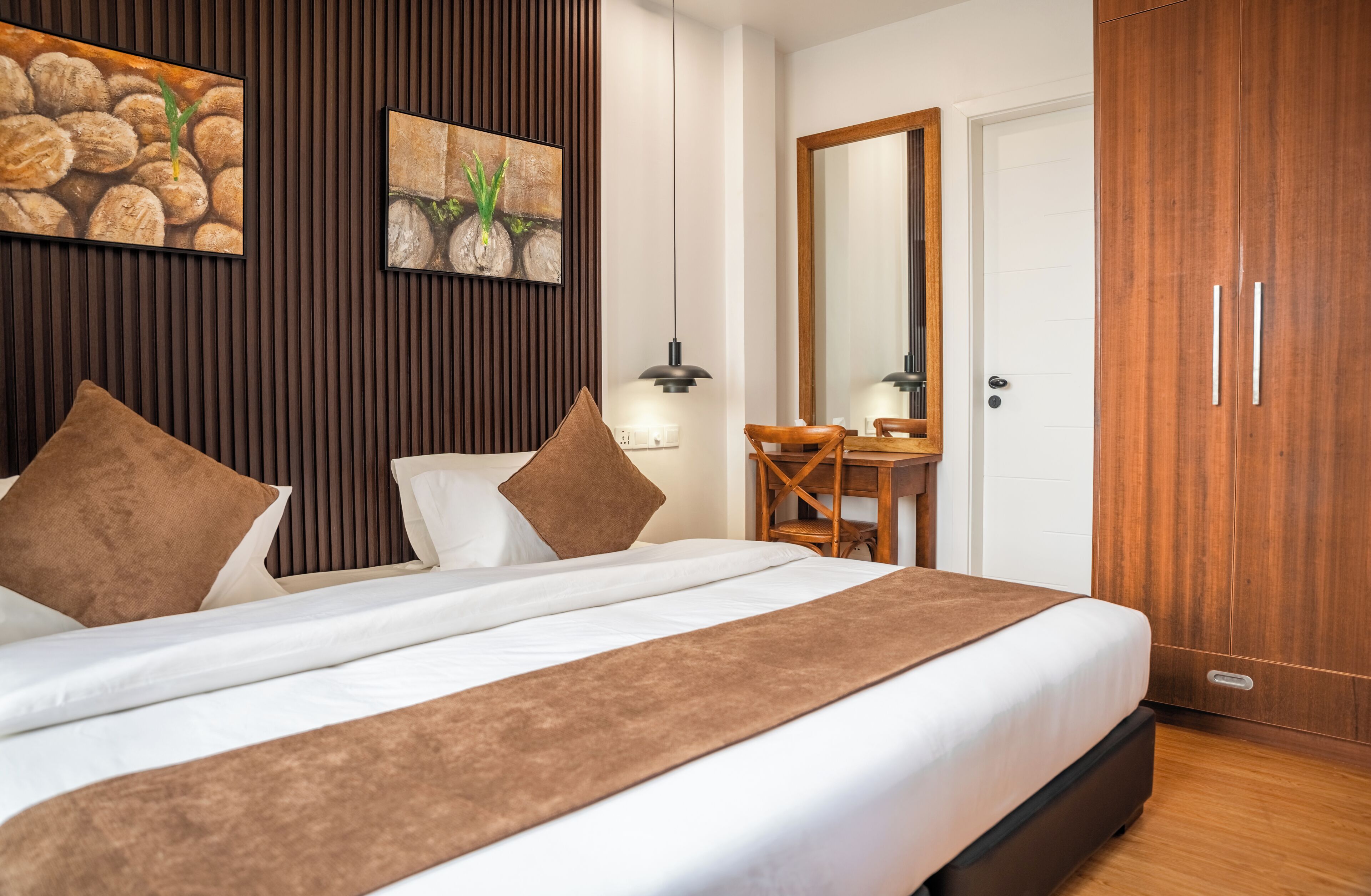 Una habitación de hotel con cama, escritorio, espejo y armario.