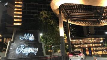 A hotel entrance with a sign reading "Hotel Regency" and a modern architectural structure above it.