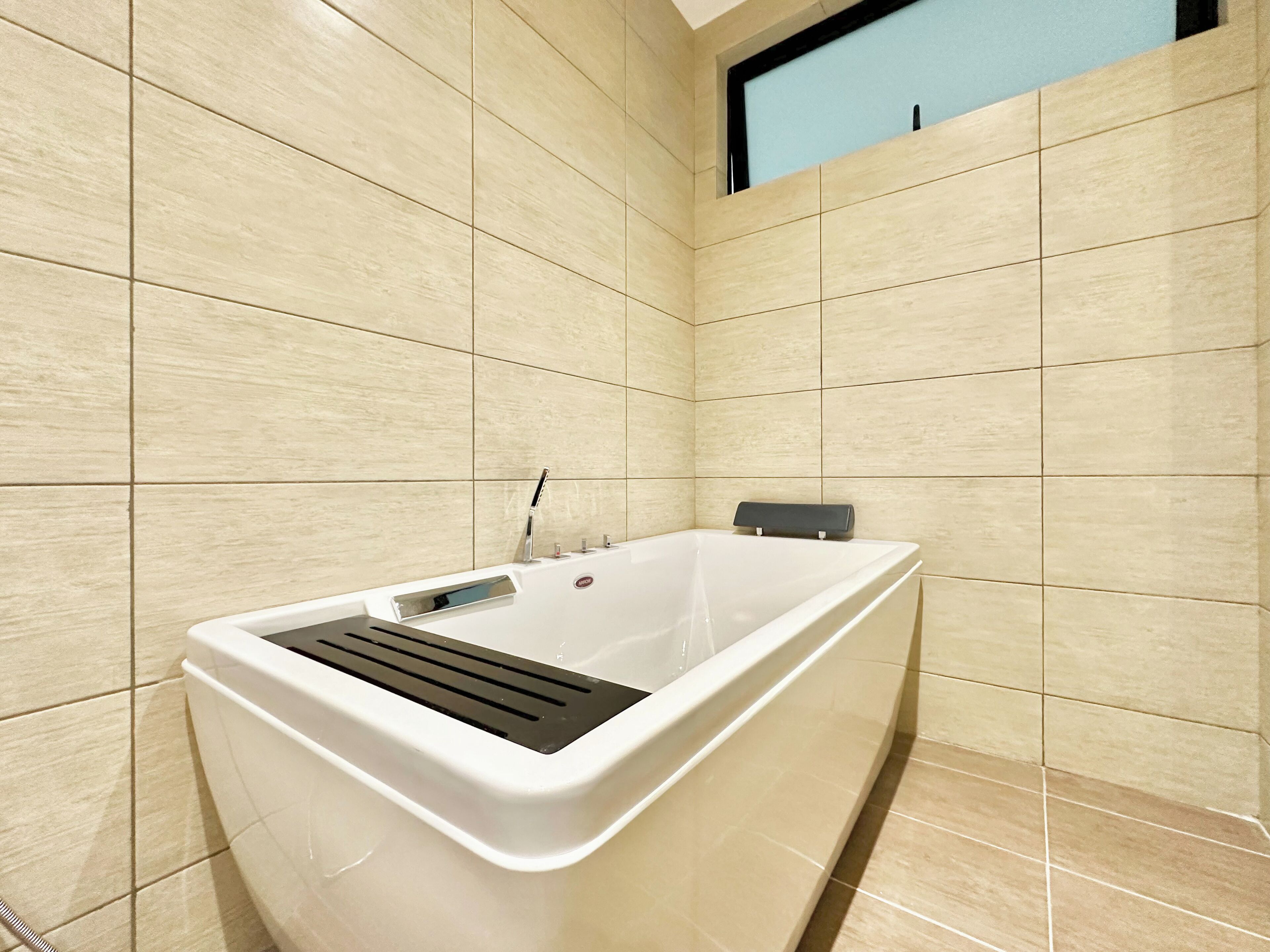 A modern bathroom with a freestanding bathtub, a built-in shower, and a window above the bathtub.
