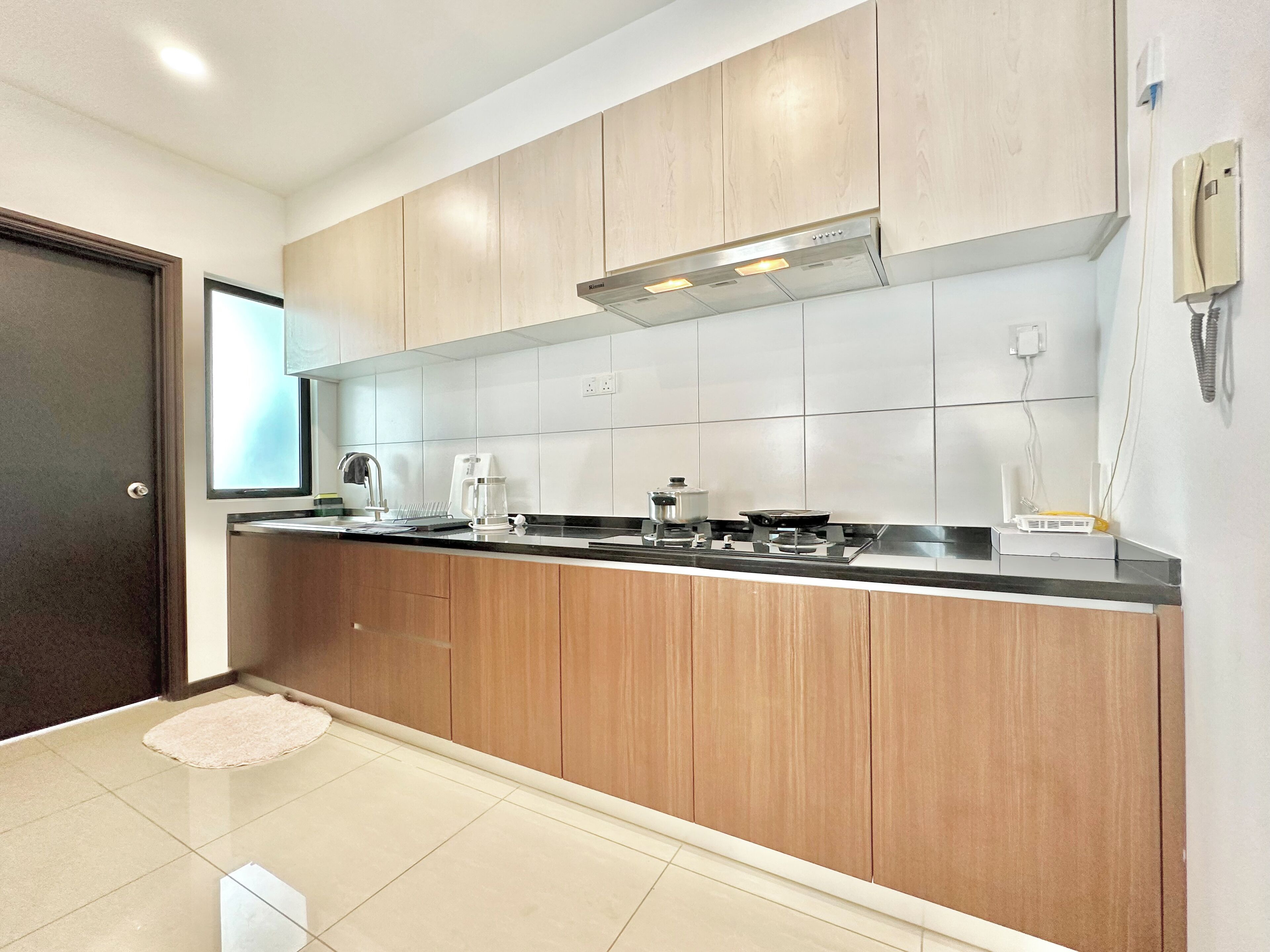 A modern kitchen with wooden cabinets, a stainless steel range hood, and a built-in oven.