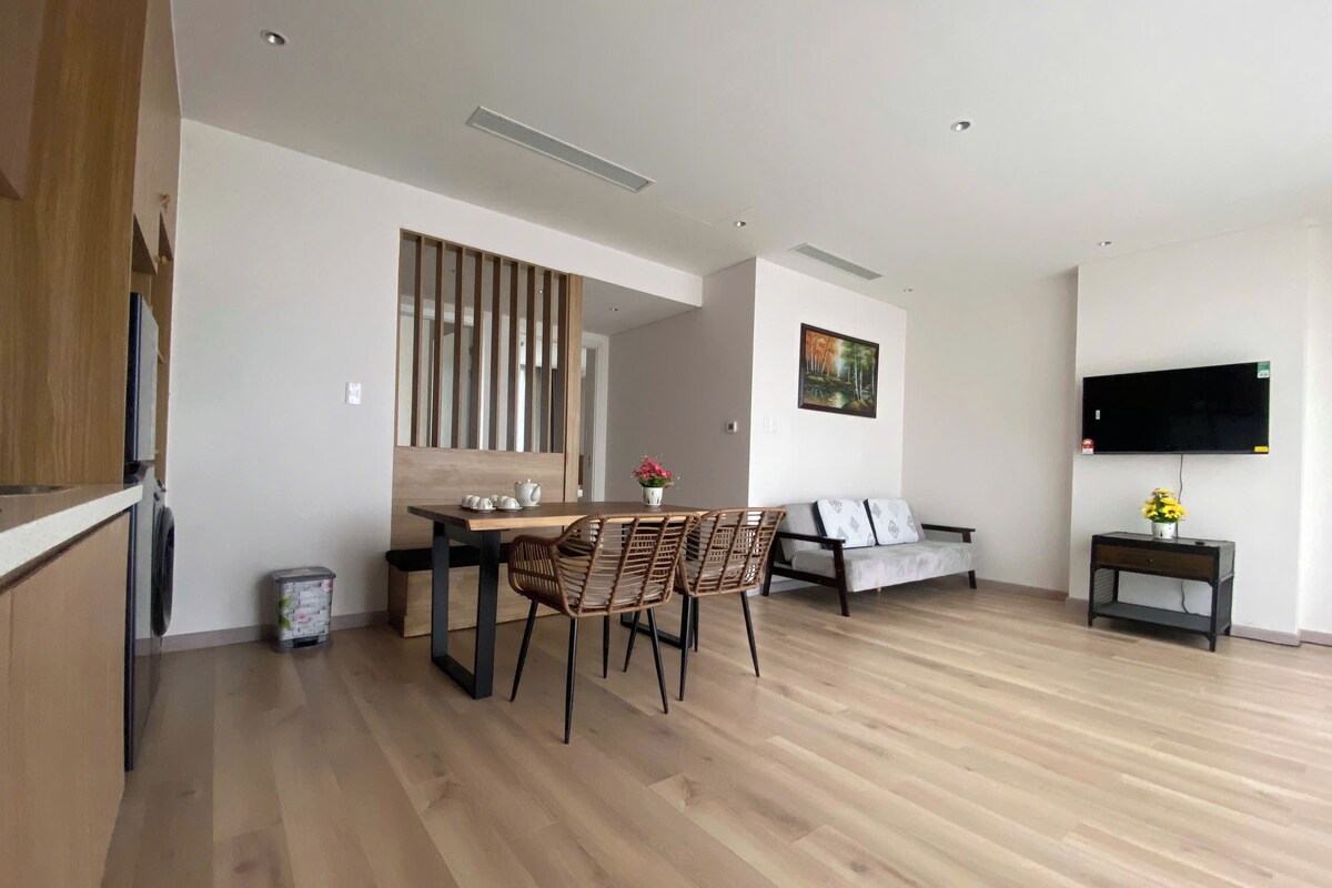A modern living space with a dining area, sofa, and TV.