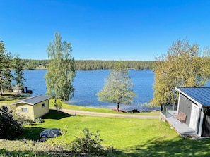 Une propriété au bord du lac, comprenant une petite maison, une terrasse et une vue dégagée sur le lac.