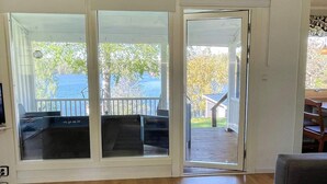 Une pièce dotée d’une grande porte-fenêtre coulissante donnant sur une terrasse aménagée avec du mobilier d’extérieur.