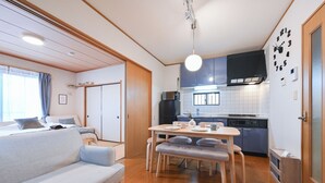A compact living space with a sofa, dining table, and kitchenette. - A 15-minute taxi ride from Haneda Airport. A perfect standalone house for families and groups to use as a base during their stay in Tokyo. (Ota-ku)