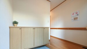 A hallway with a wooden cabinet, a potted plant, and a wooden floor. - A 15-minute taxi ride from Haneda Airport. A perfect standalone house for families and groups to use as a base during their stay in Tokyo. (Ota-ku)