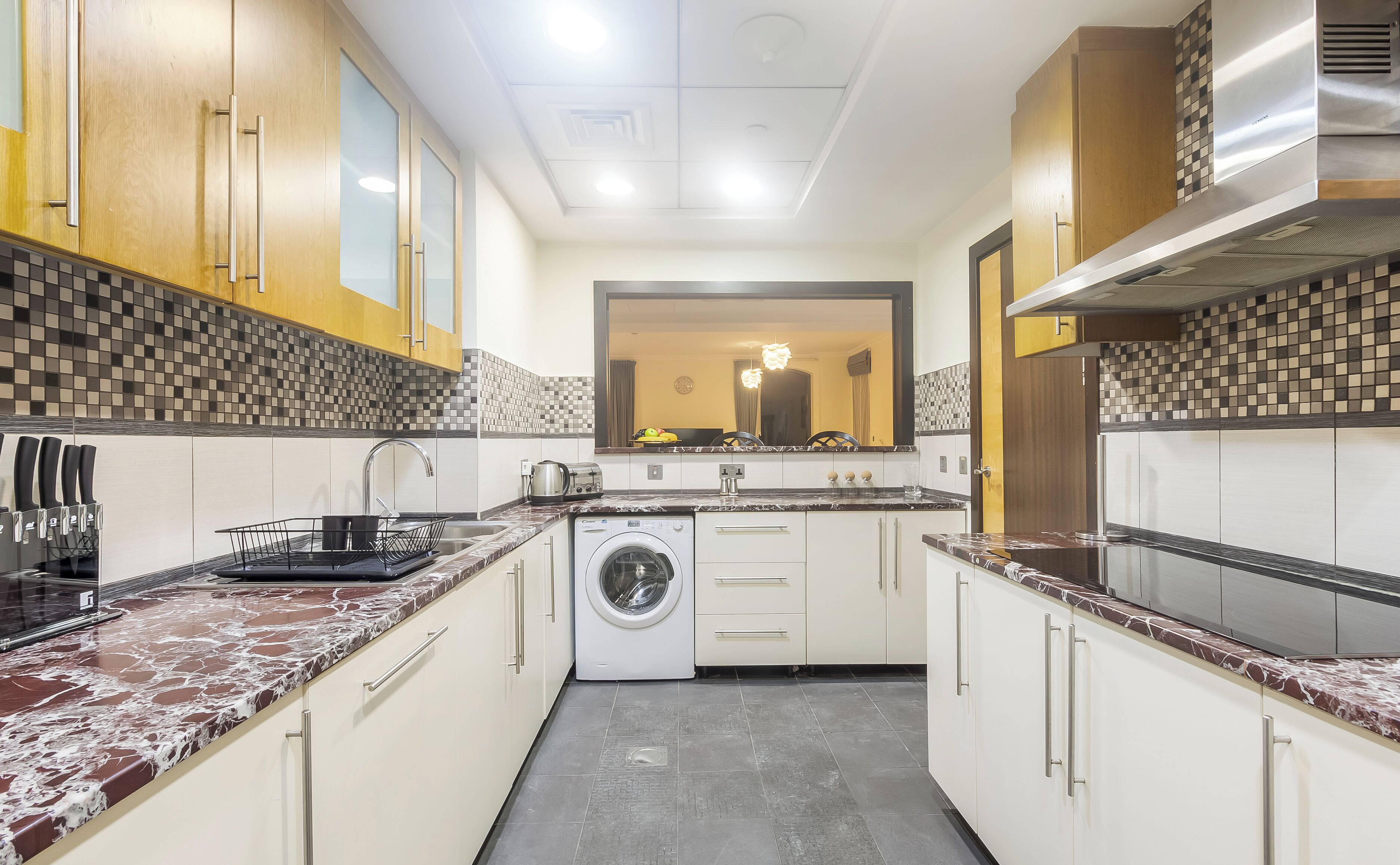 Una cocina compacta con lavadora, pileta y estufa.