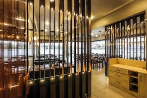Ein Restaurantinneres mit einer Holzwand, Hängeleuchten und einer Sitzgelegenheit.
