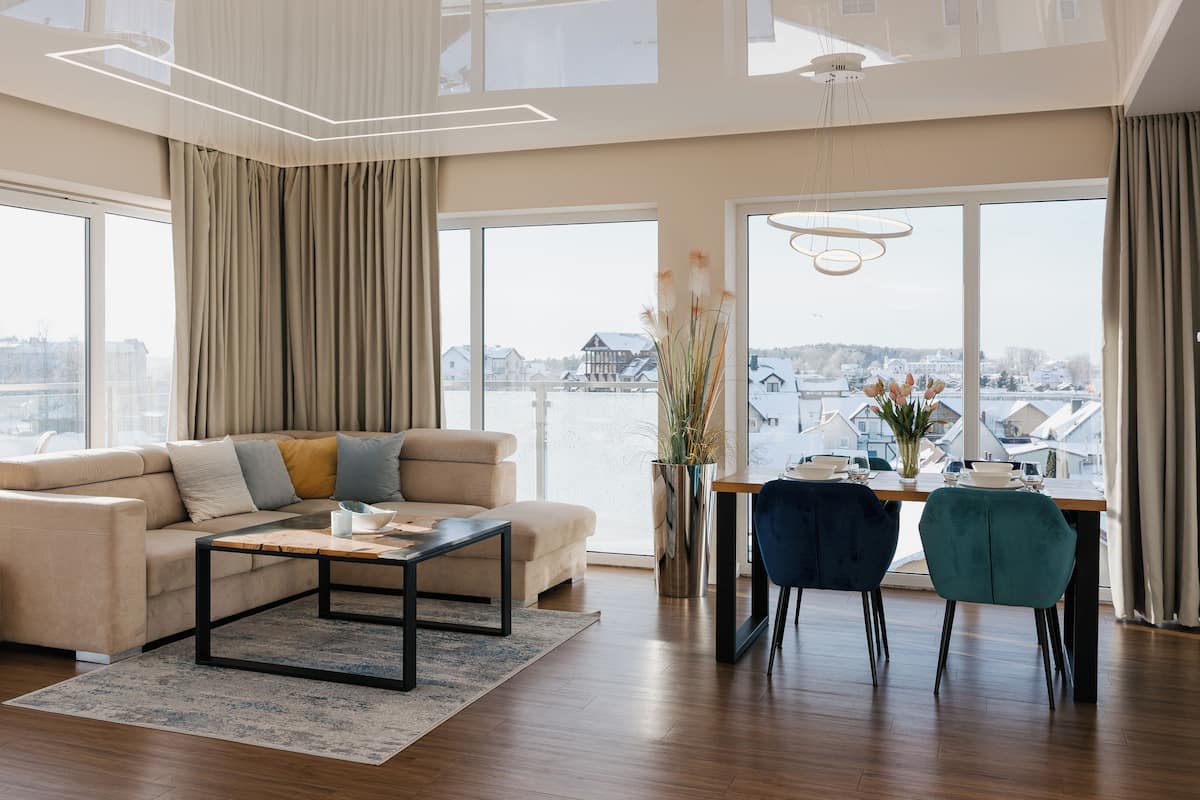 A modern living room with a sofa, coffee table, and dining area with chairs.