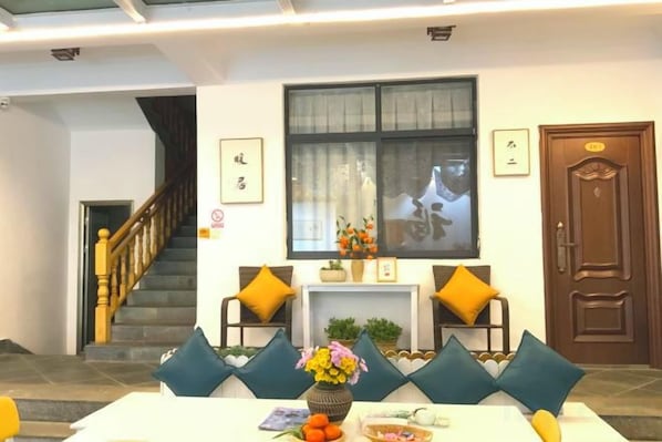 A hotel lobby with a staircase, a reception desk, and a door. - 798 Inn (Dali)
