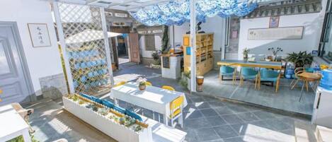 A spacious indoor area with a glass ceiling, a reception desk, and seating arrangements.