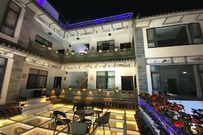 A multi-level courtyard with outdoor seating, a glass table, and a balcony with railings. - 798 Inn (Dali)