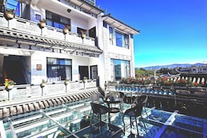 A two-story building with a glass terrace and outdoor seating. - 798 Inn (Dali)