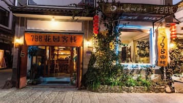 A traditional Chinese courtyard with a shop entrance, stone steps, and a tiled floor.