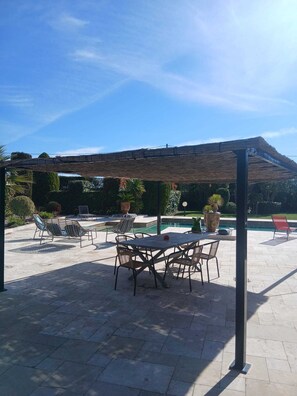 Eine Außenpatio mit Pool, Sitzgelegenheiten und einer Pergola.