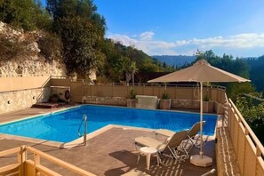 A rectangular swimming pool with a clear blue water, surrounded by a wooden deck and lounge chairs. - Aegean View Villa, 2-min Drive to Almyrida Beach with Private Pool and Views (Chania)