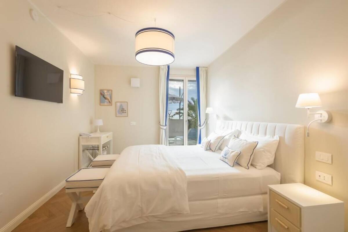Un dormitorio con una cama grande, mesitas de noche, un televisor y una lámpara de techo.