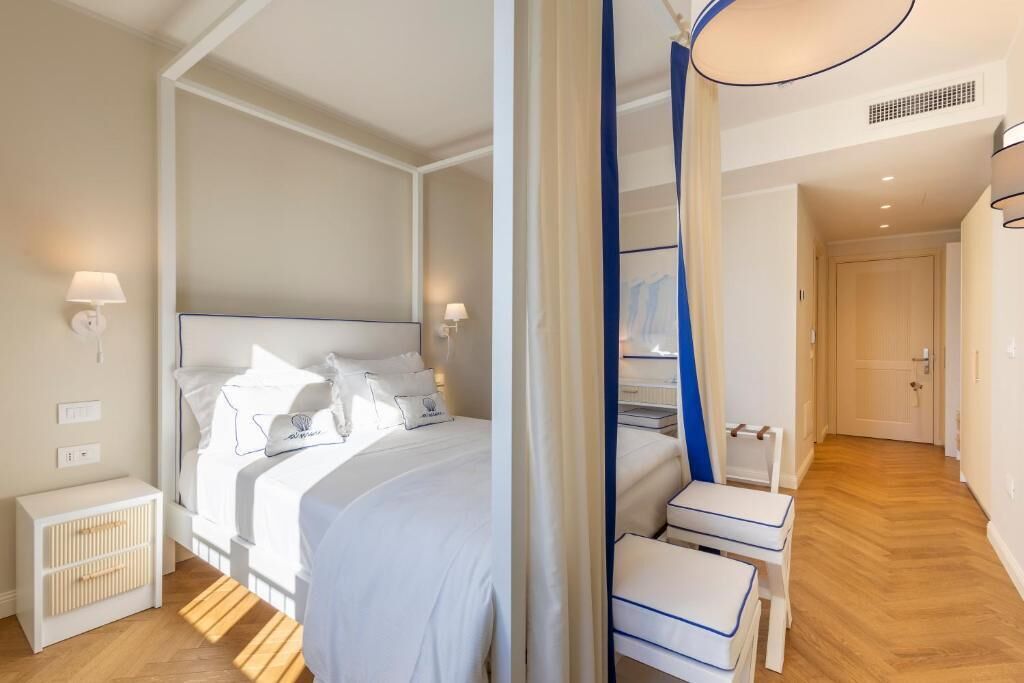 A modern bedroom with a large bed, bedside tables, and a walk-in closet.