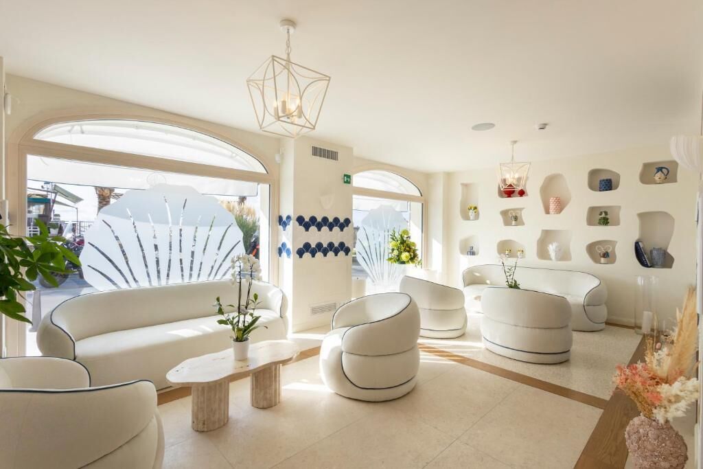 Un salon moderne avec des canapés blancs, une table basse et des objets décoratifs accrochés aux murs.