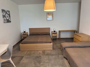 Une chambre à coucher avec un lit en bois, des tables de chevet, un bureau et une chaise.