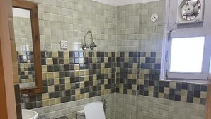 Kylpyhuone, jossa on wc, pesuallas ja peili.