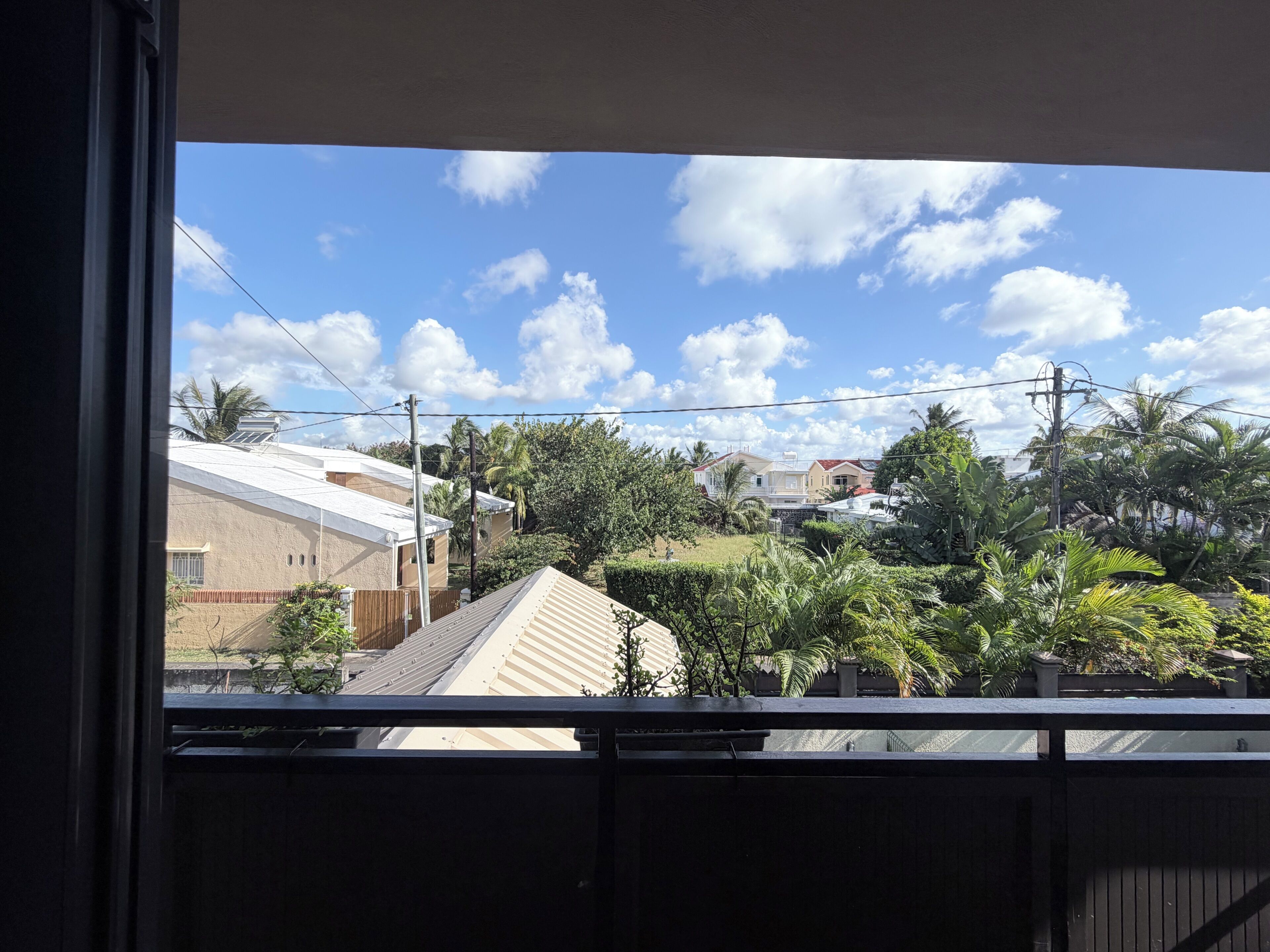 A residential area with houses, trees, and a clear sky.