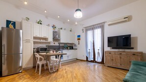 A modern kitchen with a refrigerator, microwave, and dining area. - GuestHost - Cozy and comfortable 56 square meters apartment, perfect for four people, located on the first floor of a renovated period building with an elevator (NOT accessible to disabled guests).The property is located just steps from Palermo's histori (Palermo)