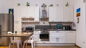 A modern kitchen with white cabinets, stainless steel appliances, and a wooden floor. - GuestHost - Cozy and comfortable 56 square meters apartment, perfect for four people, located on the first floor of a renovated period building with an elevator (NOT accessible to disabled guests).The property is located just steps from Palermo's histori (Palermo)