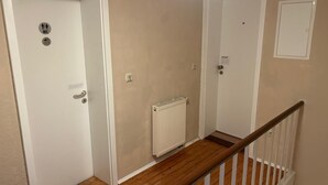 A staircase with wooden steps and white railings, leading to a room with beige walls and white doors. - Beautiful, cozy accommodation with separate rooms, shared kitchen and bathroom (Langgöns)