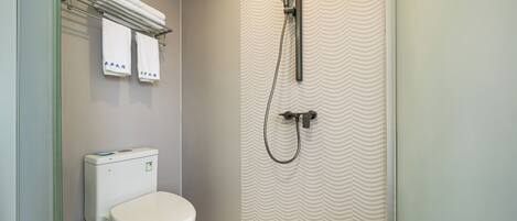 A bathroom with a toilet, a shower, and a towel rack with towels.