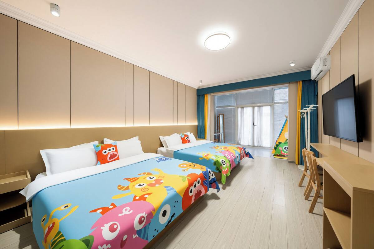 A hotel room with three beds, a TV, and a window with curtains.