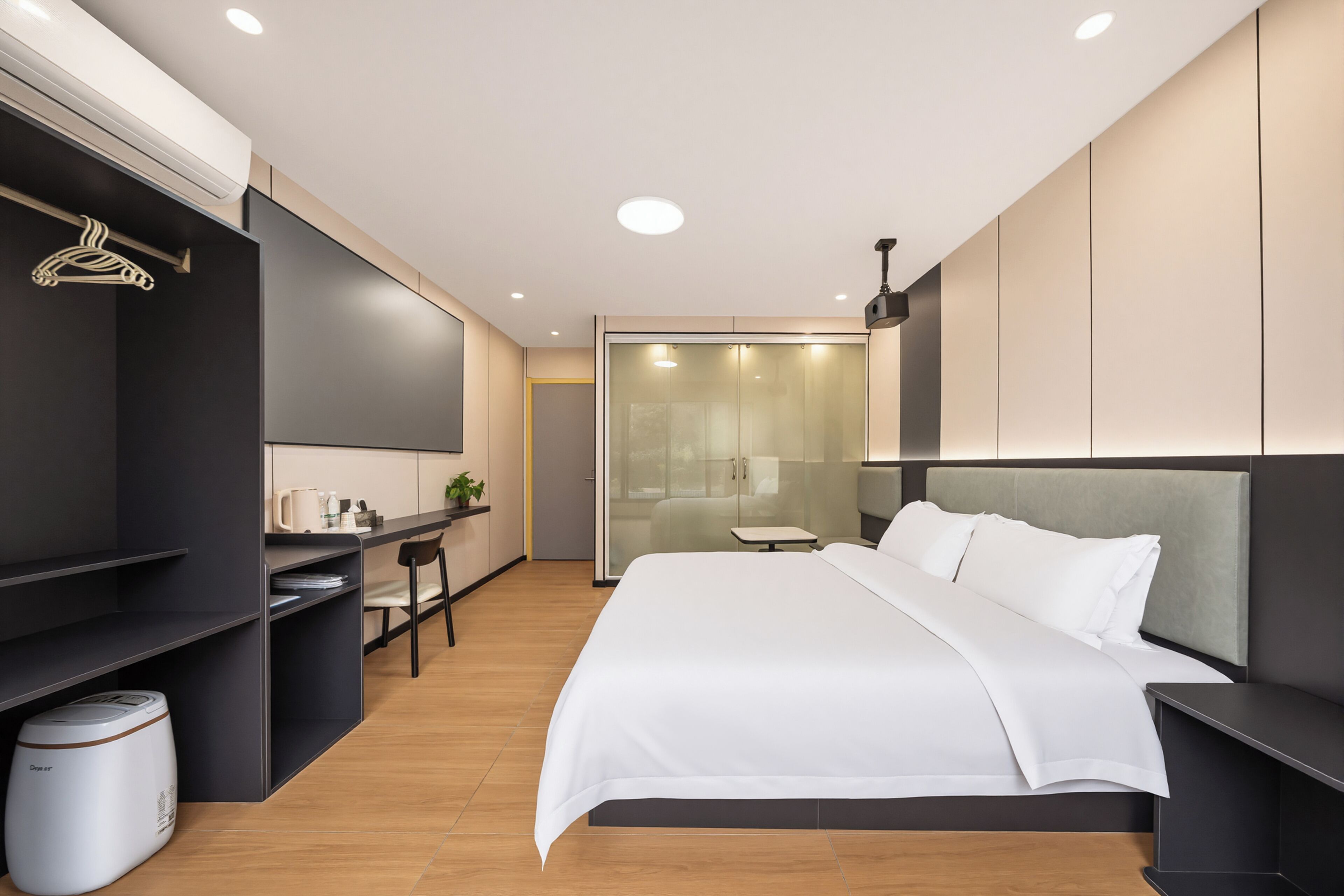 Un dormitorio moderno con una cama grande, un escritorio y un armario.