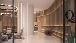 Una hall moderna con soffitto curvo, scrivania della reception, area salotto e un'ampia parete di vetro con un logo.